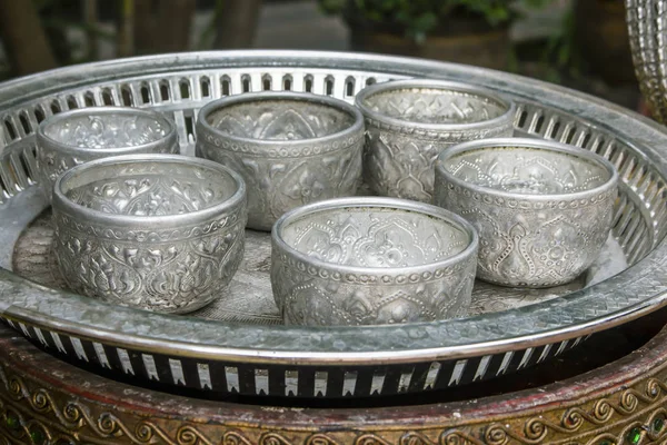 Пустые традиционные тайские миски с водой в богато украшенном серебряном подносе, часто видны в храмах, чтобы вылить святую воду . — стоковое фото
