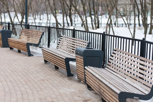 Benches in the park. Wooden benches and urns. Winter empty park