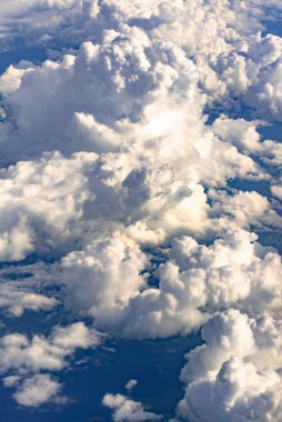 Uçak penceresindeki bulutlar. Güzel gökyüzü ve bulutlar denizi, yukarıdan çekilmiş bir fotoğraf. Çeşitli bulut türleri.