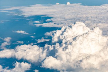 Uçak penceresindeki bulutlar. Güzel gökyüzü ve bulutlar denizi, yukarıdan çekilmiş bir fotoğraf. Çeşitli bulut türleri.