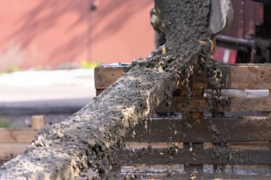 Beton ahşap bir tepsiye dökülüyor. Kaynaştıkça, beton bir sürü püskürtüyor..