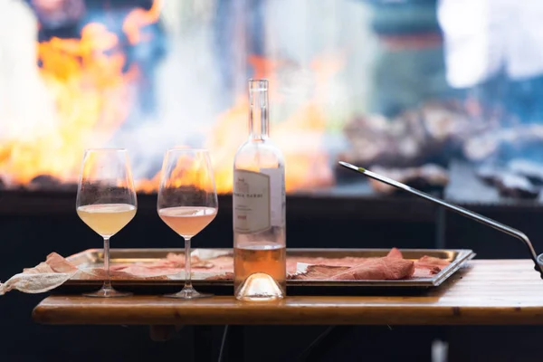 Orange and white wine in glasses. Cooking meat and drinking wine. Wine on the background of a large grill.
