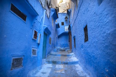 Mavi şehrin güzel manzarası CheFCHAOUEN, Medina 'daki MoroCCO. Geleneksel Fas mimari detayları ve boyalı evler. Kapısı olan bir sokak ve kemerli parlak mavi duvarlar