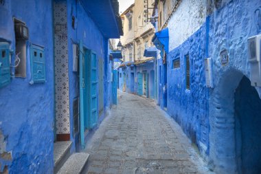 Mavi şehrin güzel manzarası CheFCHAOUEN, Medina 'daki MoroCCO. Geleneksel Fas mimari detayları ve boyalı evler. Kapısı olan bir sokak ve kemerli parlak mavi duvarlar