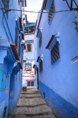 Mavi şehrin güzel manzarası CheFCHAOUEN, Medina 'daki MoroCCO. Geleneksel Fas mimari detayları ve boyalı evler. Kapısı olan bir sokak ve kemerli parlak mavi duvarlar