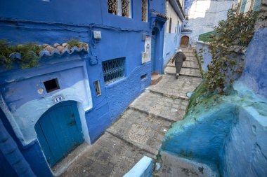 Mavi şehrin güzel manzarası CheFCHAOUEN, Medina 'daki MoroCCO. Geleneksel Fas mimari detayları ve boyalı evler. Kapısı olan bir sokak ve kemerli parlak mavi duvarlar