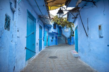 Mavi şehrin güzel manzarası CheFCHAOUEN, Medina 'daki MoroCCO. Geleneksel Fas mimari detayları ve boyalı evler. Kapısı olan bir sokak ve kemerli parlak mavi duvarlar