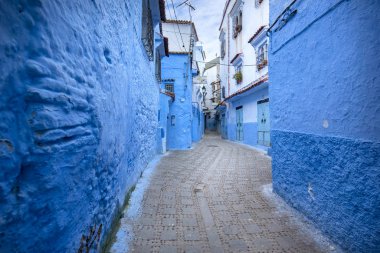 Mavi şehrin güzel manzarası CheFCHAOUEN, Medina 'daki MoroCCO. Geleneksel Fas mimari detayları ve boyalı evler. Kapısı olan bir sokak ve kemerli parlak mavi duvarlar