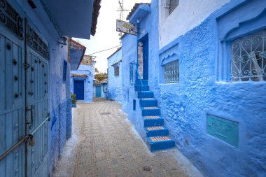 Mavi şehrin güzel manzarası CheFCHAOUEN, Medina 'daki MoroCCO. Geleneksel Fas mimari detayları ve boyalı evler. Kapısı olan bir sokak ve kemerli parlak mavi duvarlar
