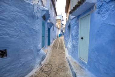 Mavi şehrin güzel manzarası CheFCHAOUEN, Medina 'daki MoroCCO. Geleneksel Fas mimari detayları ve boyalı evler. Kapısı olan bir sokak ve kemerli parlak mavi duvarlar