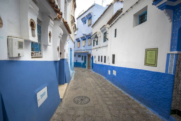 Beautiful view of the blue city in the medina. Traditional moroccan architectural details and painted houses.  street with door and bright blue walls with arch in CHEFCHAOUEN, MOROCCO