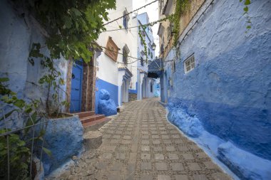 Medine 'deki mavi şehrin güzel manzarası. Geleneksel Fas mimari detayları ve boyalı evler. Kapısı ve parlak mavi duvarları olan sokak Chefchaouen, Fas