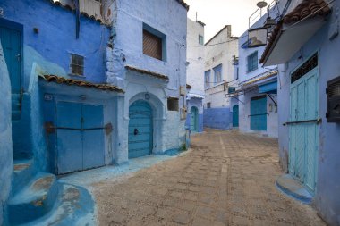 Medine 'deki mavi şehrin güzel manzarası. Geleneksel Fas mimari detayları ve boyalı evler. Kapısı ve parlak mavi duvarları olan sokak Chefchaouen, Fas