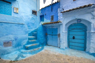 Medine 'deki mavi şehrin güzel manzarası. Geleneksel Fas mimari detayları ve boyalı evler. Kapısı ve parlak mavi duvarları olan sokak Chefchaouen, Fas