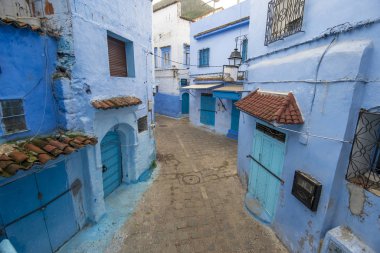 Medine 'deki mavi şehrin güzel manzarası. Geleneksel Fas mimari detayları ve boyalı evler. Kapısı ve parlak mavi duvarları olan sokak Chefchaouen, Fas