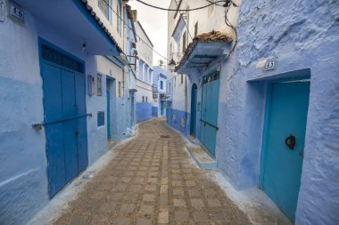 Medine 'deki mavi şehrin güzel manzarası. Geleneksel Fas mimari detayları ve boyalı evler. Kapısı ve parlak mavi duvarları olan sokak Chefchaouen, Fas