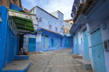 Medine 'deki mavi şehrin güzel manzarası. Geleneksel Fas mimari detayları ve boyalı evler. Kapısı ve parlak mavi duvarları olan sokak Chefchaouen, Fas