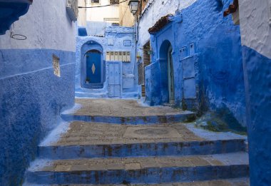 Medine 'deki mavi şehrin güzel manzarası. Geleneksel Fas mimari detayları ve boyalı evler. Kapısı ve parlak mavi duvarları olan sokak Chefchaouen, Fas