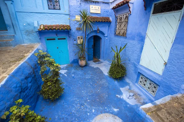Beautiful view of the blue city in the medina. Traditional moroccan architectural details and painted houses.  street with door and bright blue walls with arch in CHEFCHAOUEN, MOROCCO