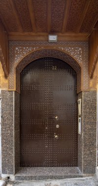 Geleneksel Fas tarzı bir antik ahşap giriş kapısı tasarımı. Marakeş, Fas 'taki eski Medine' de. Tipik, eski, karmaşık bir şekilde oyulmuş, çivili, Fas riad kapısı.