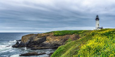 Panoramik manzara Yaquina Baş Olağanüstü Doğal Alanı deniz feneri ve kayalık bazaltik burunlarıyla Oregon Sahili, Newport, Usa.