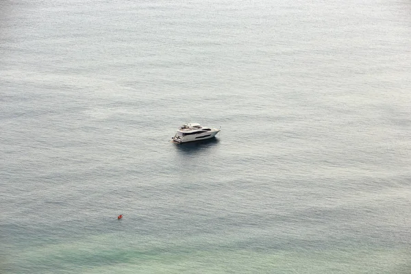 Orange kayak and a yacht — Stock Photo, Image