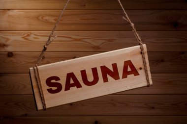 Güzel bir ahşap arka plan üzerinde kaba bir ip üzerinde kelime Sauna ile Ahşap tabela