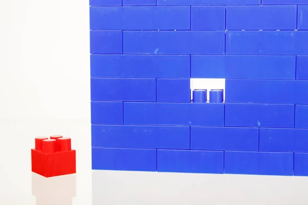 Стіна синього дитячого барвистого пластику будівельних іграшок цегли, з однією відсутньою частиною — стокове фото