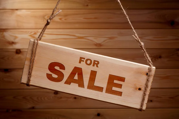 Holzschild mit den Worten zum Verkauf auf einem groben Seil auf schönem Holzgrund — Stockfoto
