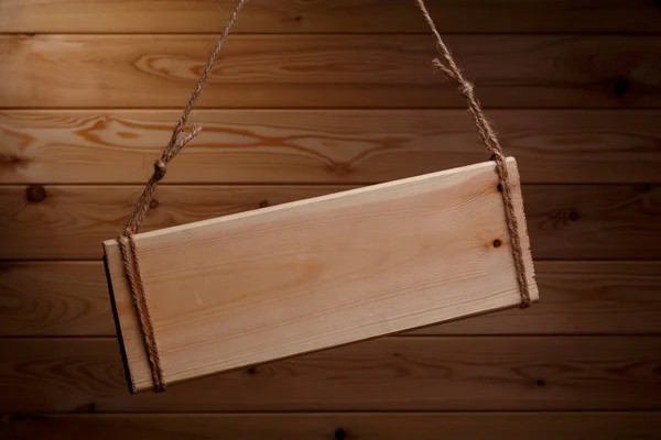 Houten uithangbord op een ruw touw op een mooie houten achtergrond — Stockfoto