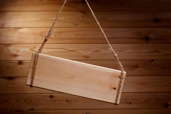 Letrero de madera sobre una cuerda áspera sobre un hermoso fondo de madera —  Fotos de Stock