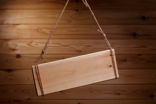 Houten uithangbord op een ruw touw op een mooie houten achtergrond — Stockfoto