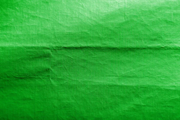 Dirty crumpled green synthetic fabric texture with a well-traced light and shadow pattern