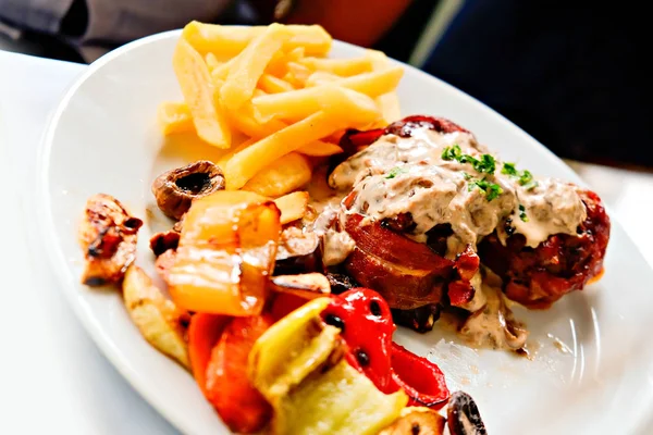 Kızarmış domuz pastırması ve mantar soslu tavuk filetosu.