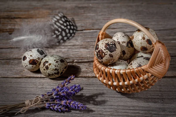 Quail eggs on a wooden background in a basket — Stock Photo, Image