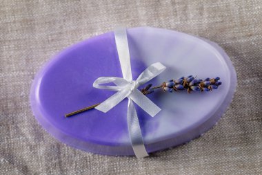 Narin mor renklerde el yapımı gliserin sabun beyaz bir fiyonk ve keten peçetede lavanta.