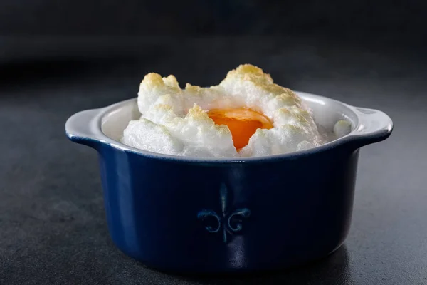 精美的烤鸡蛋Orsini 云中的鸡蛋 在漆黑的背景下 穿着蓝色衬裙的法国早餐 — 图库照片