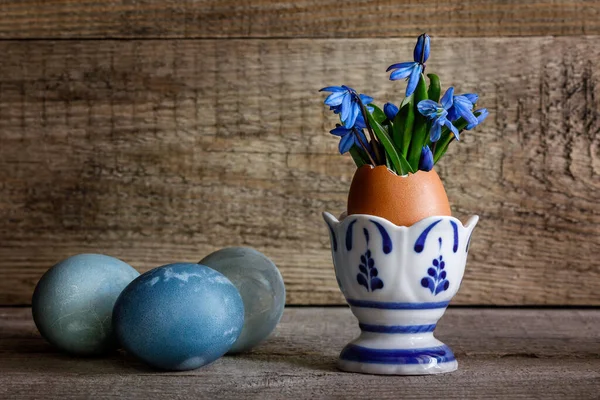 Paaseieren Sneeuwklokjes Een Eierstatief Een Houten Ondergrond — Stockfoto