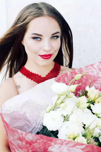 Frau in weißem Kleid mit einem Strauß weißer Blumen in rosa Papier gewickelt. — Stockfoto