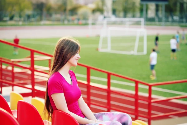 Bonita sorridente torcedor de futebol feminino assistindo jogo de futebol — Fotografia de Stock