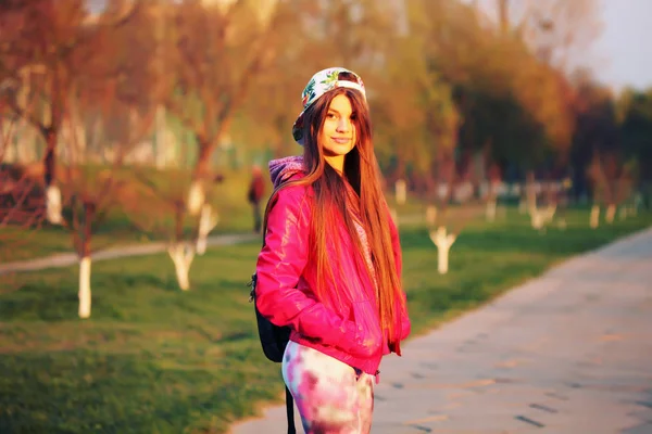 Corredor femenina. Chica elegante con ropa deportiva de moda, gorra de béisbol, con una mochila después de un entrenamiento. Aire libre, estilo de vida . —  Fotos de Stock