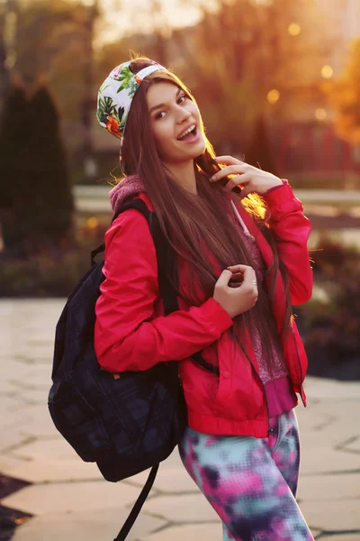 Kvinnliga löpare. Snygg tjej bär trendiga sportkläder, keps, med en ryggsäck efter ett träningspass. Utomhus, livsstil. — Stockfoto