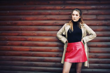 bej bir palto ve kırmızı etek kadında