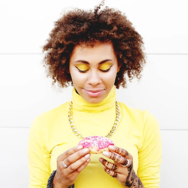 Vrouw kijken naar donut in handen — Stockfoto