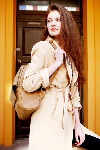 Jonge vrouw in beige trenchcoat — Stockfoto