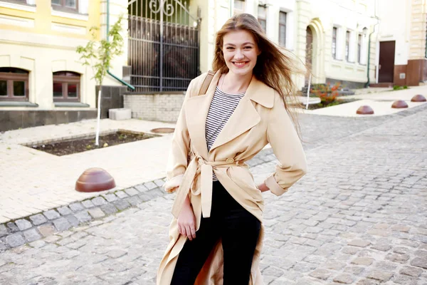 Ung kvinna i beige trenchcoat — Stockfoto