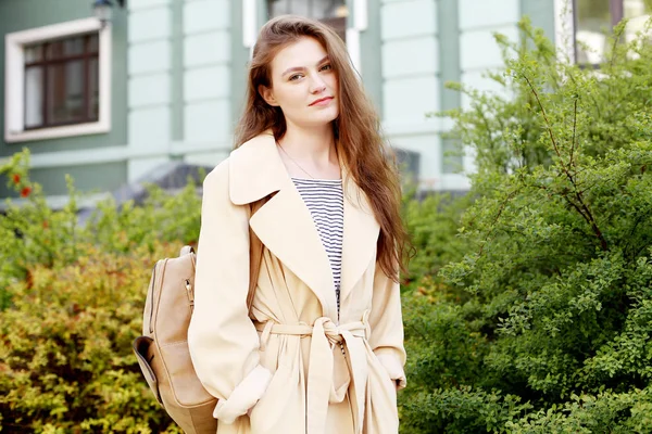 Ung kvinna i beige trenchcoat — Stockfoto