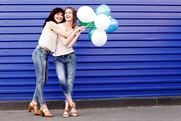 Madre con hija sosteniendo globos de aire —  Fotos de Stock