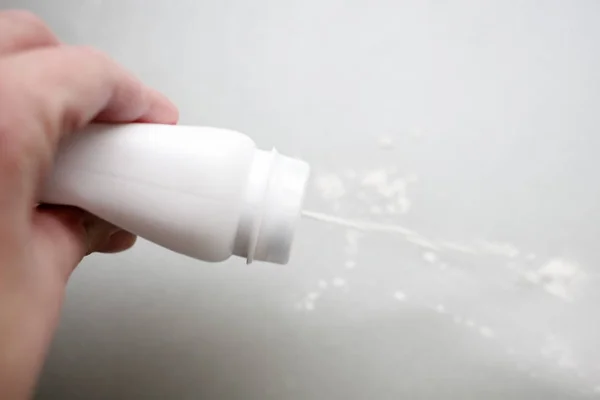 Bebek pudrası şişe tutan el