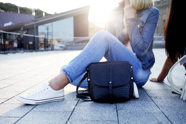 Sokağı'nda oturan kot pantolon giysili kadınlar 